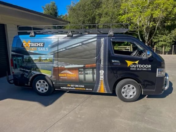 Outdoor Shade Solutions sign-written installation van parked outside a rural Waikato property
