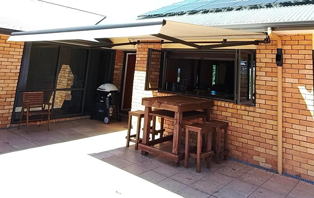 Folding arm awning over a brick patio entertaining area