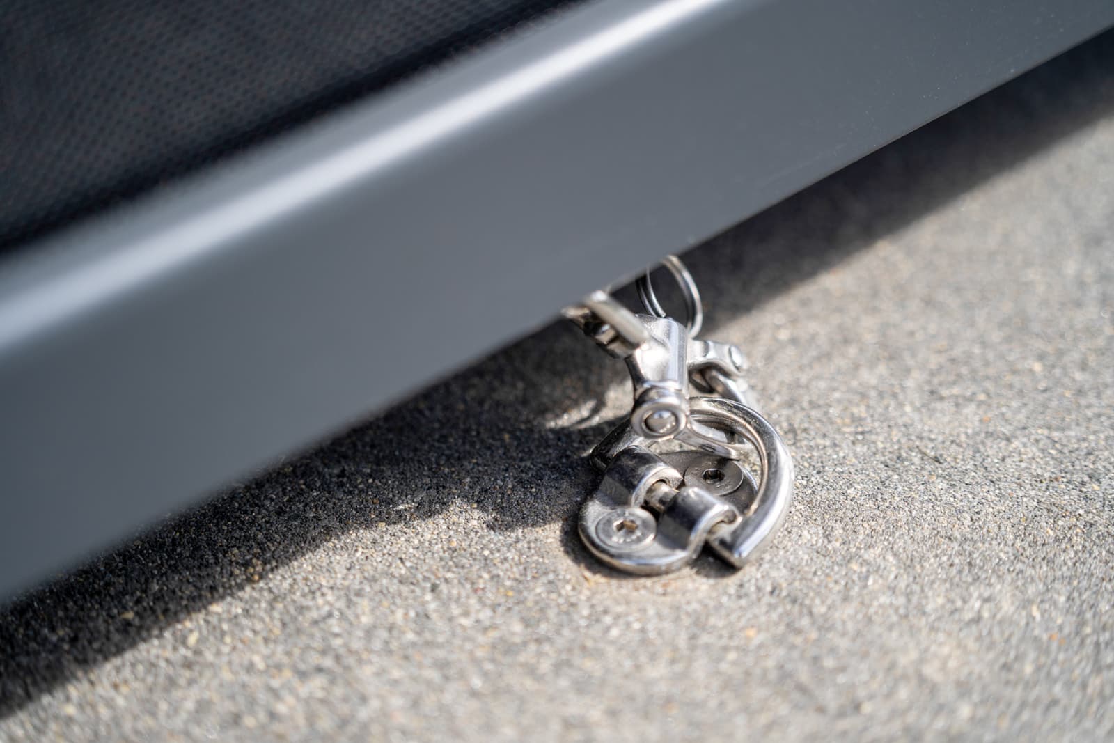 Stainless steel bottom-rail clip securing an Omni Lite outdoor blind