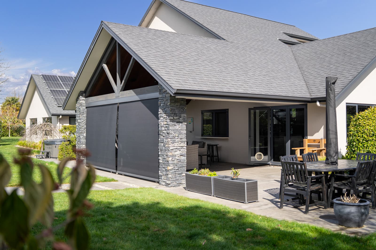 Omni Lite screen blind lowered beside bifold doors on a Waikato home