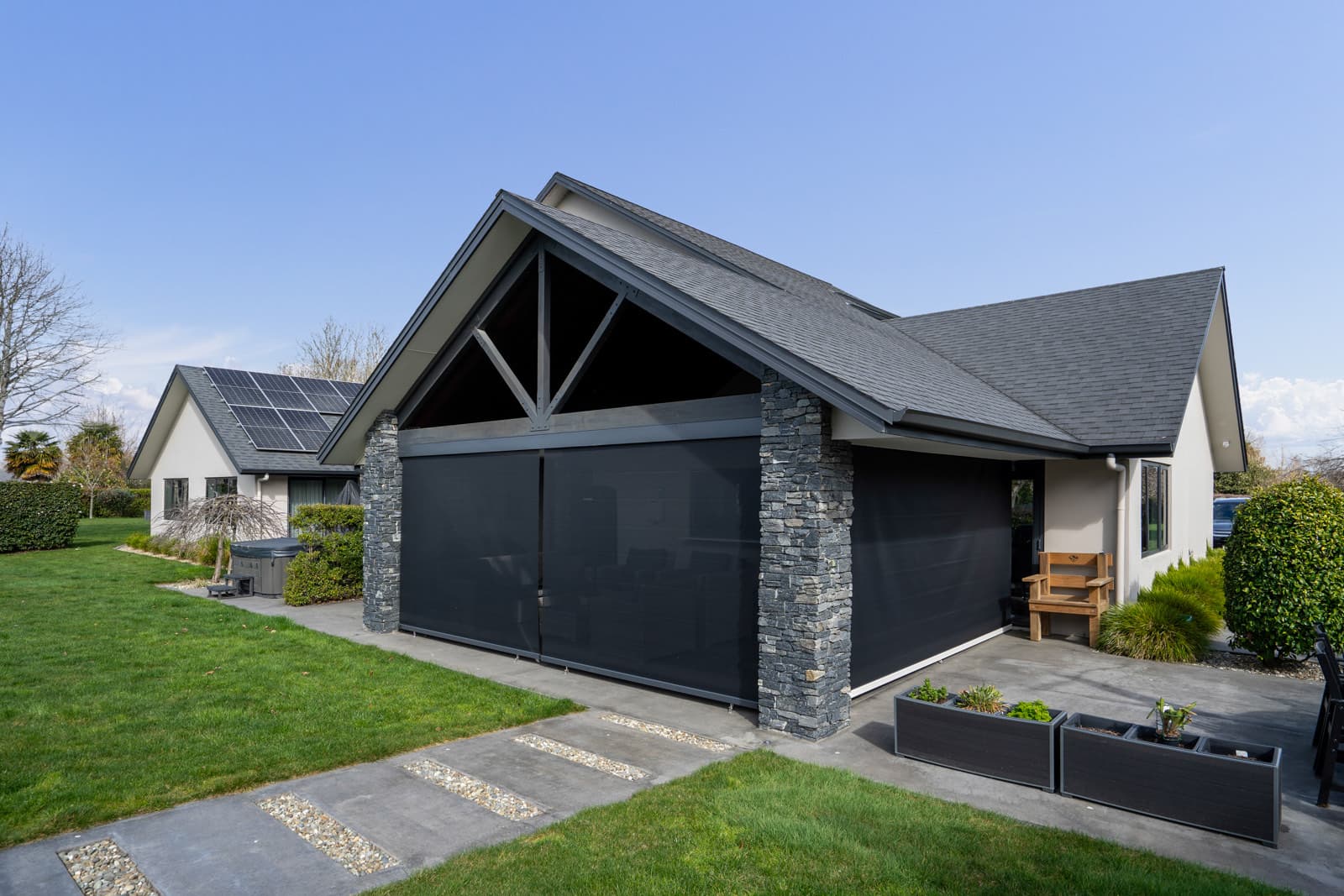 Omni Lite outdoor blinds fully lowered across a gabled outdoor room