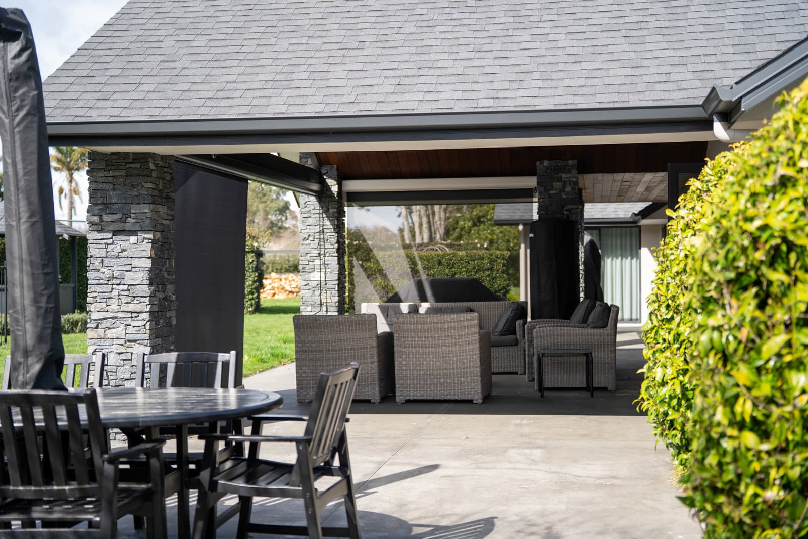 Omni Lite outdoor blinds across a multi-bay stone-columned pavilion