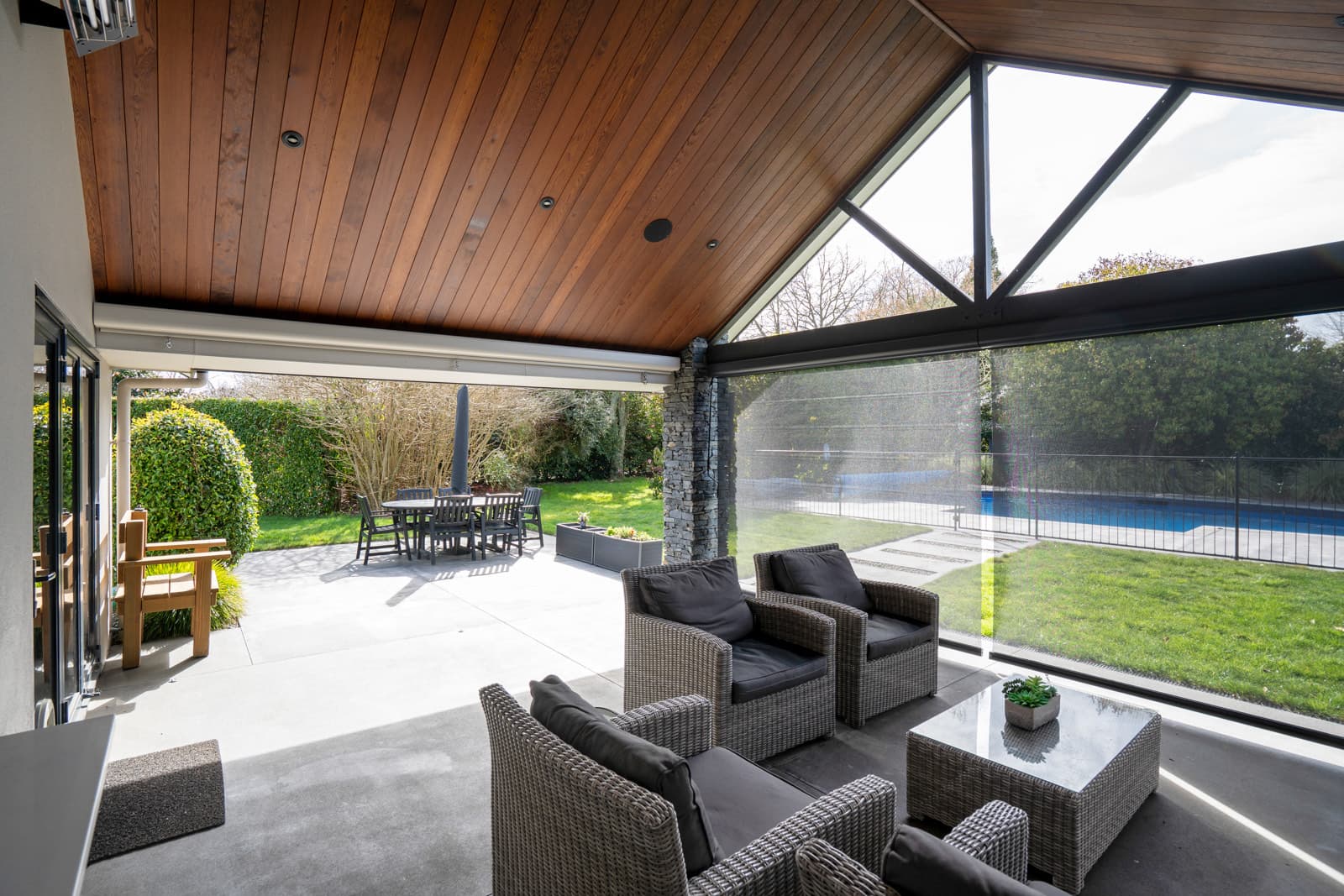 Omni Lite outdoor blinds framing a pool and garden view from a covered patio