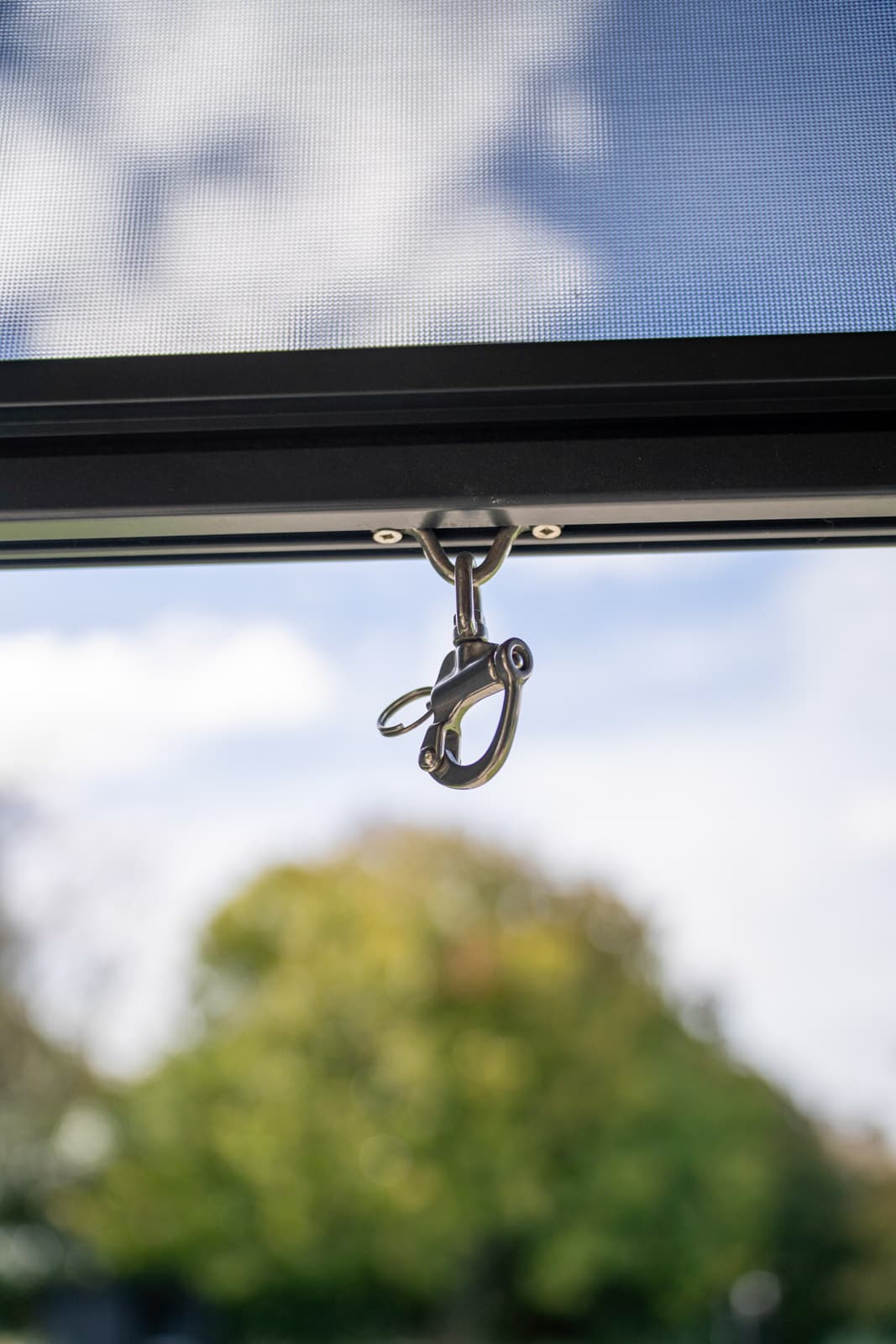 Stainless snap-hook fastening on an Omni Lite outdoor blind bottom rail