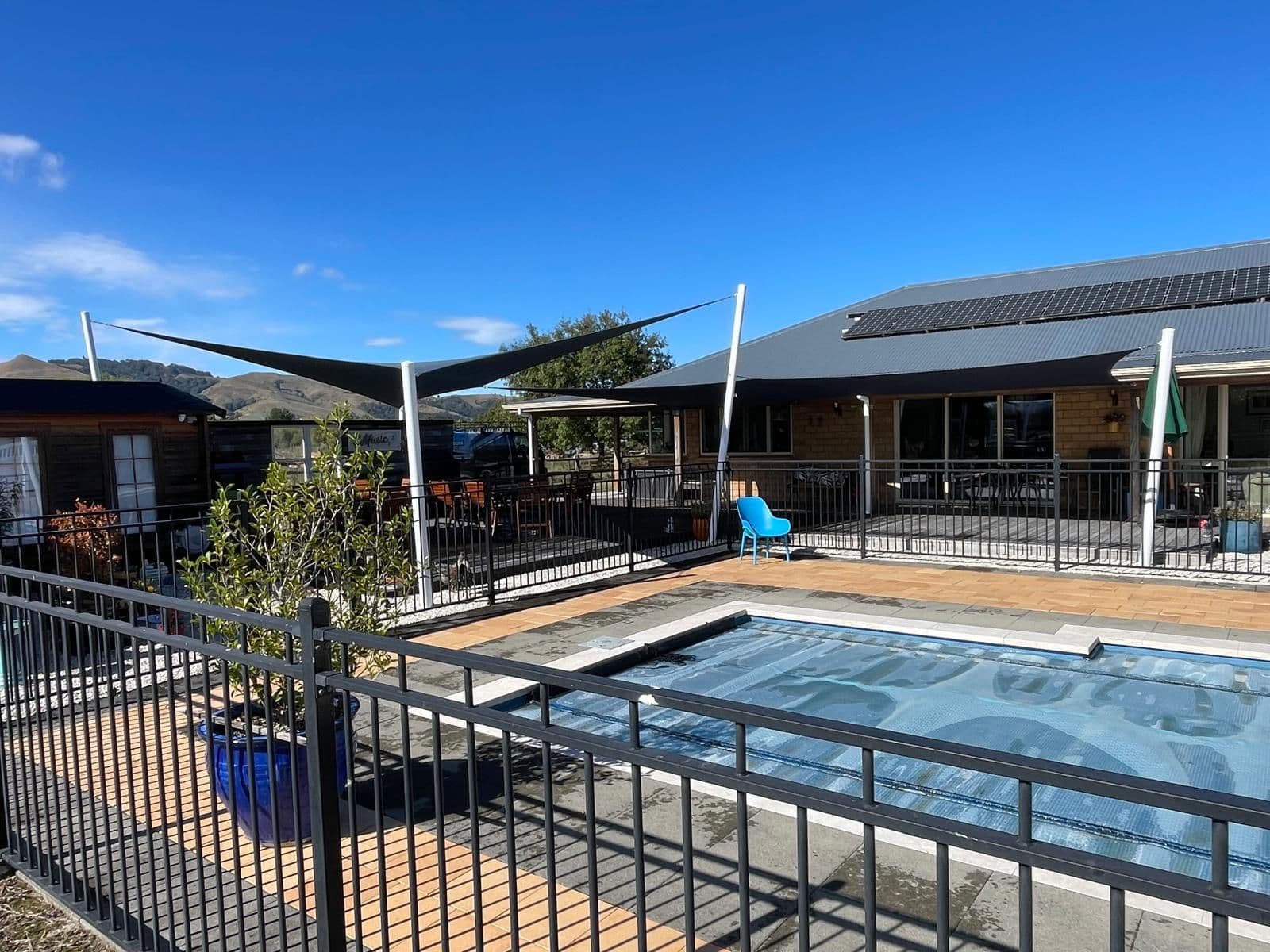 Shade sail installed over a swimming pool area