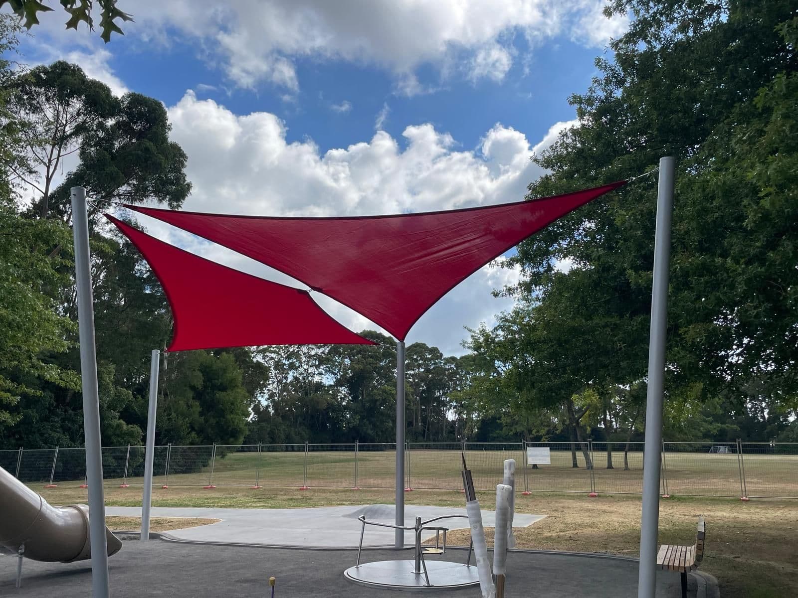 Red shade sail over playground equipment