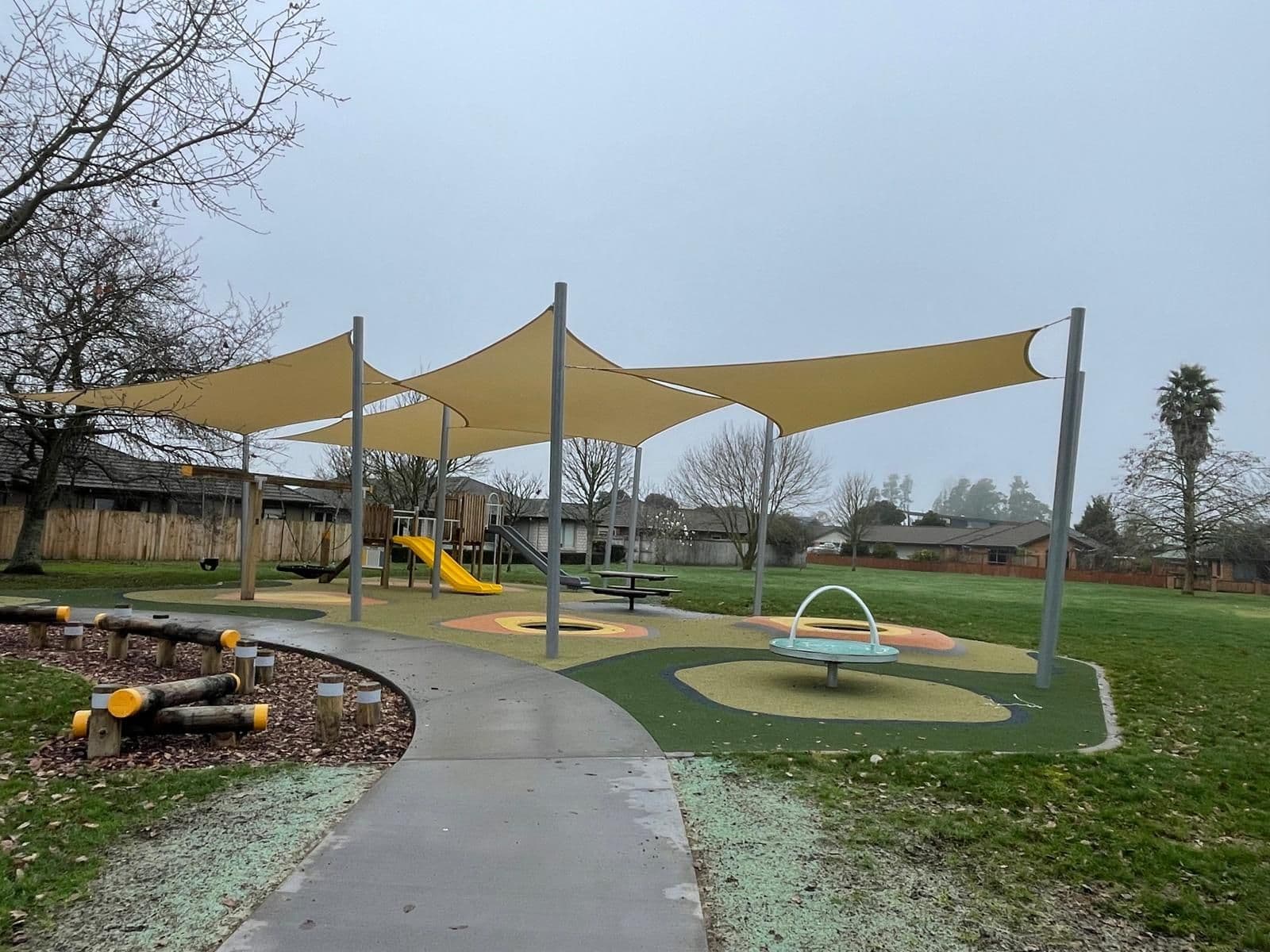 Sand-coloured shade sails over a community playground