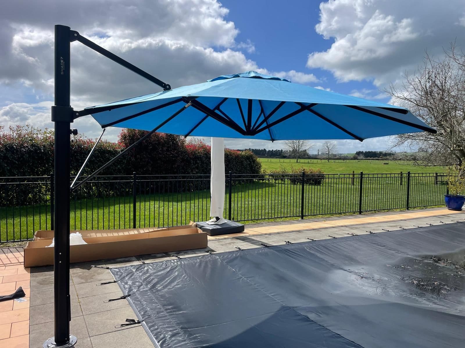 Blue cantilever umbrella installed poolside