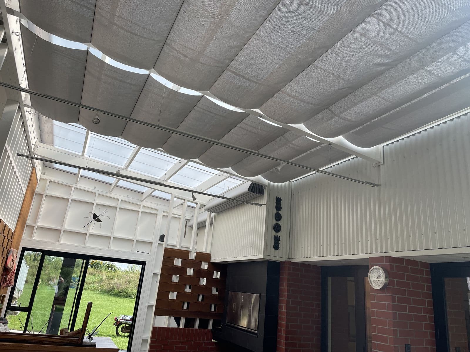White wave shade under a glass-roof pergola
