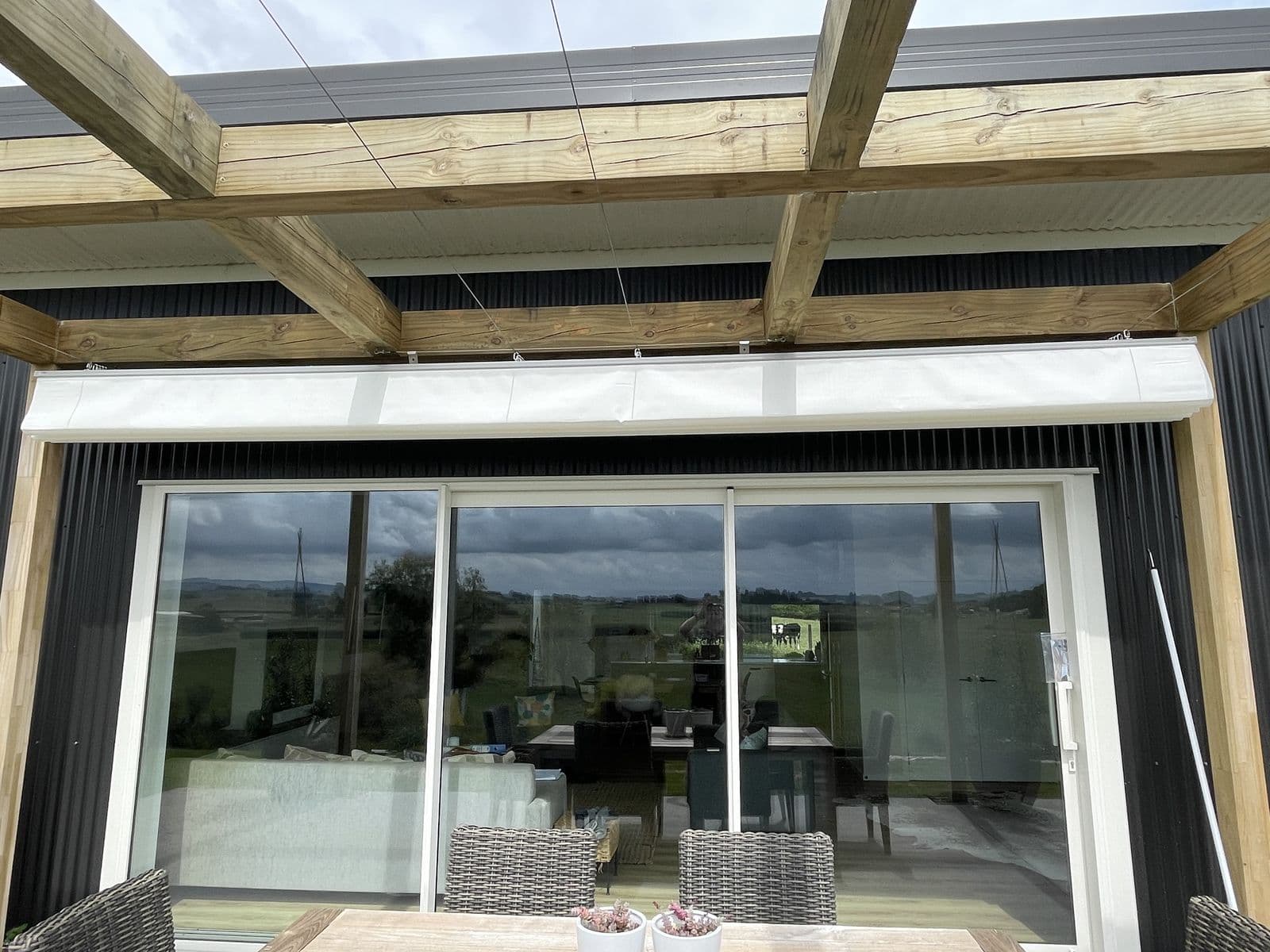 Wave shade canopy under a timber pergola with rural views