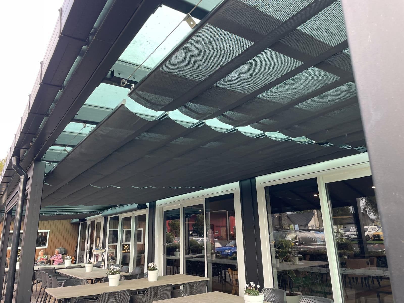 Retractable wave shades running the length of a hospitality veranda