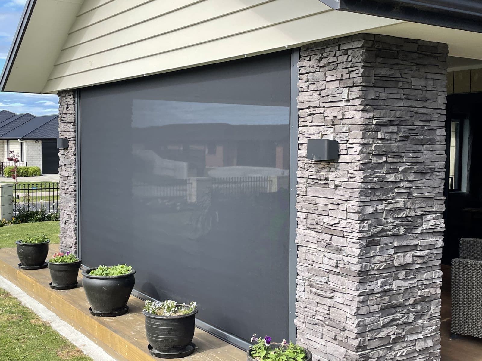 Charcoal Ziptrak screen blind beside stone pillars