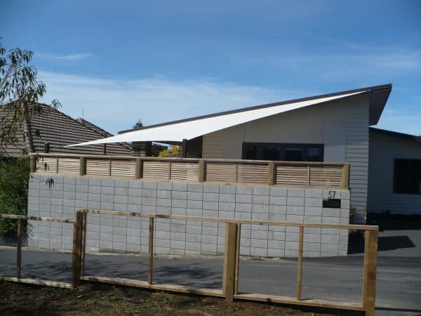 Shade sail fixed above a fenced courtyard providing all-day sun protection