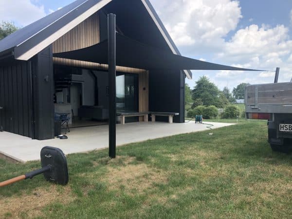 Dark shade sail providing sun protection over a residential patio in Waikato