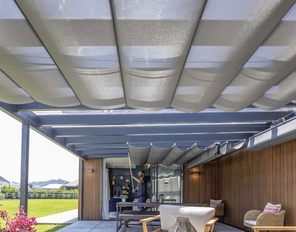 Retractable wave shade canopy over an outdoor living space in Cambridge