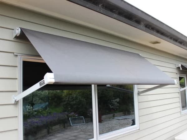 Grey retractable awning extended over a home patio