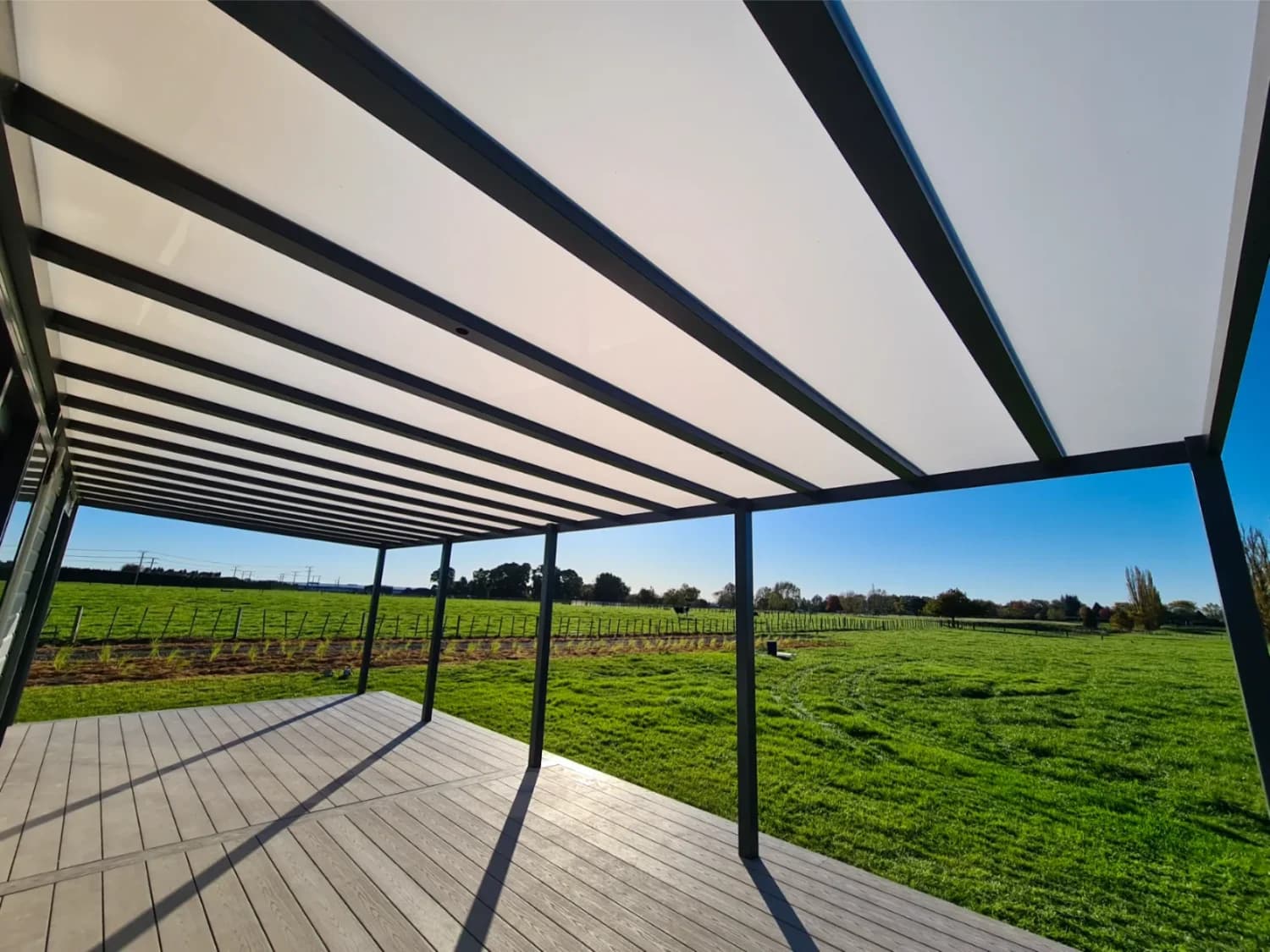 Grey tint polycarbonate roofing panels over an outdoor deck