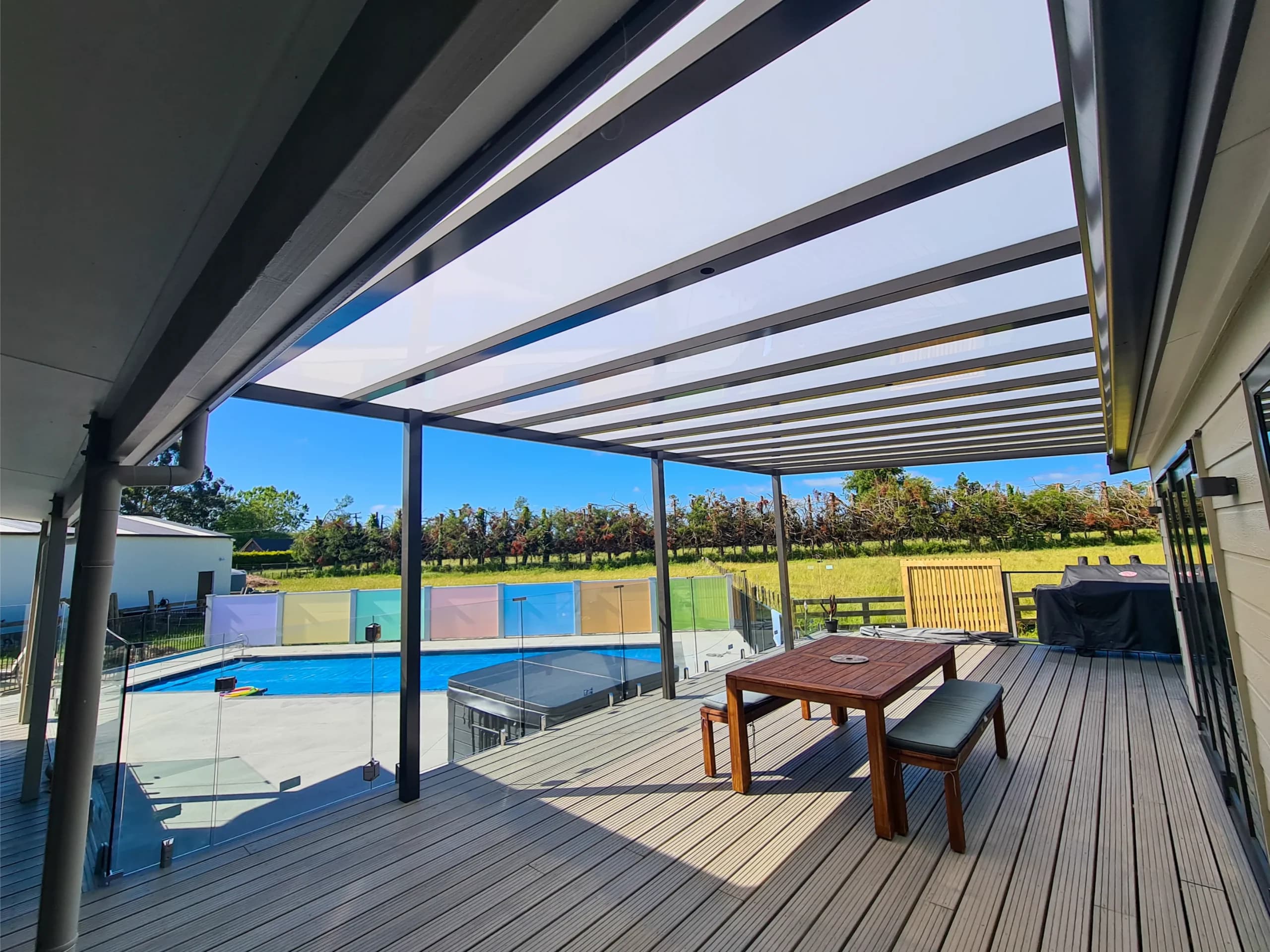 Ally-Golla aluminium pergola with diffused opal roofing over a poolside deck