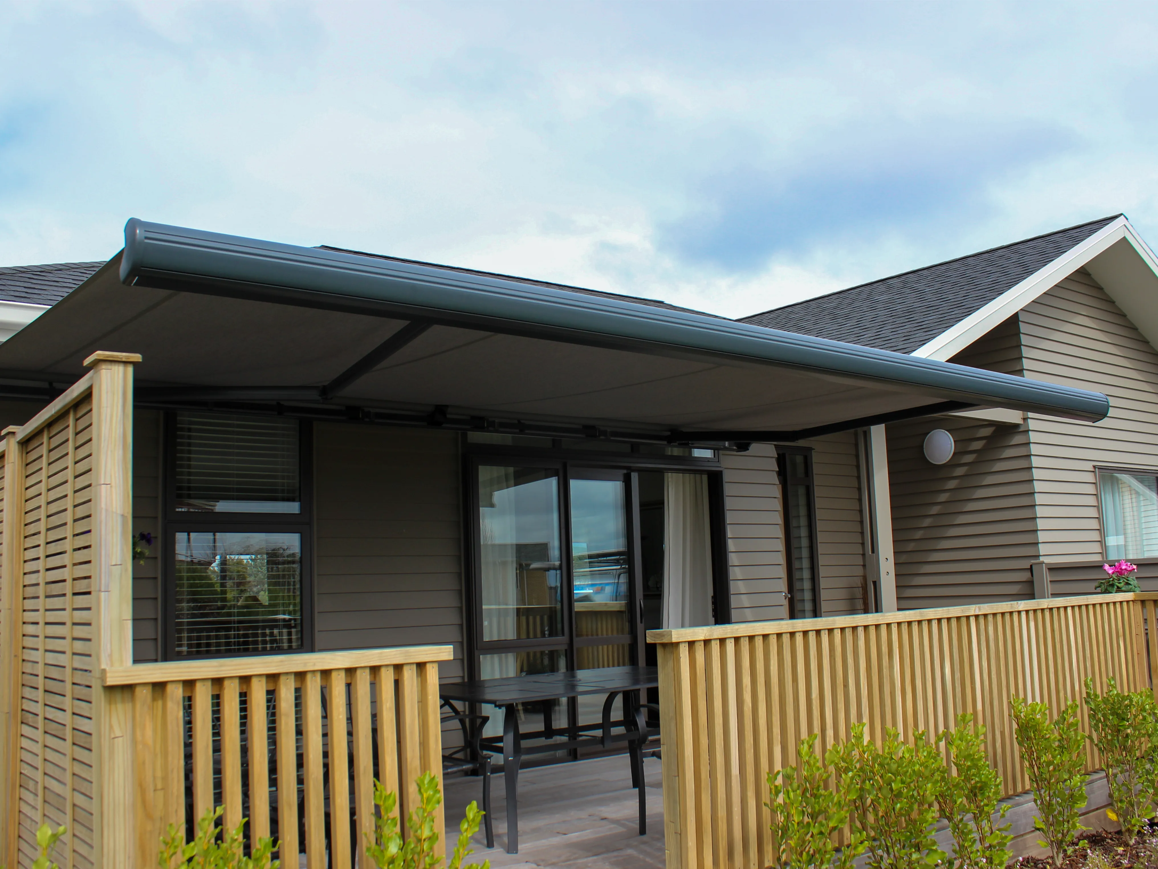Custom folding arm awning shading an outdoor entertaining area at a Waikato home