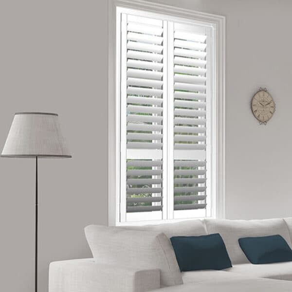 White interior window shutters in a lounge with a floor lamp