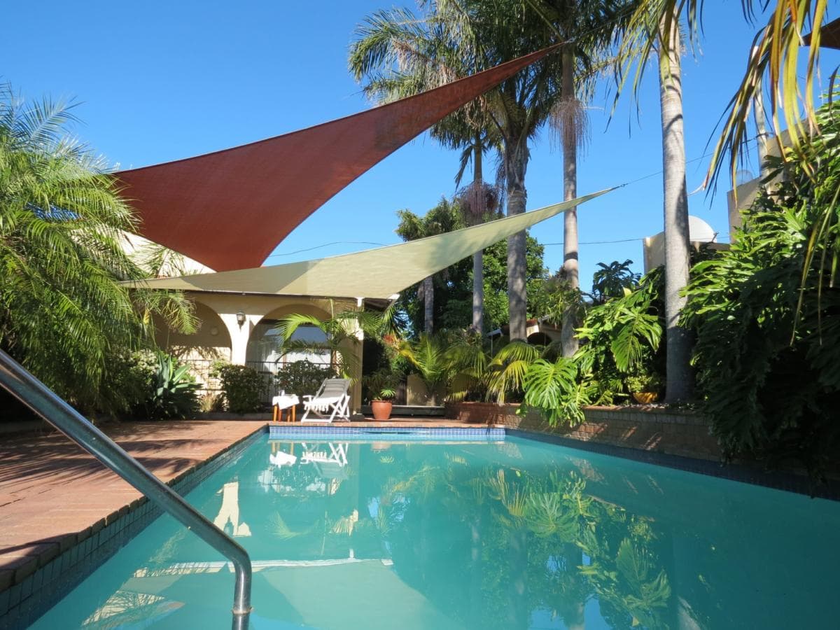Ready made shade sails installed over a backyard pool