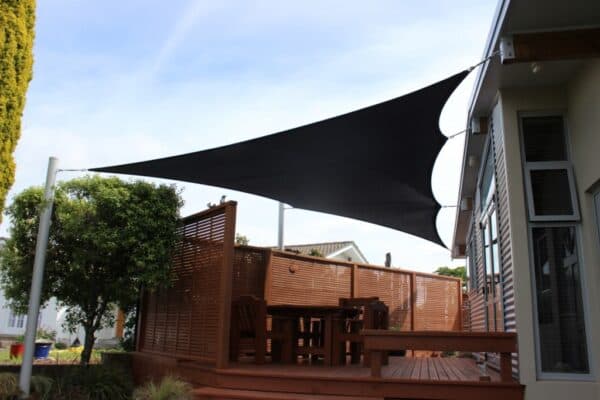 Green shade sail installed over a residential outdoor area
