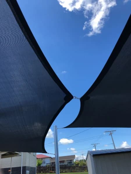 Shade sail stretched between steel posts in a courtyard