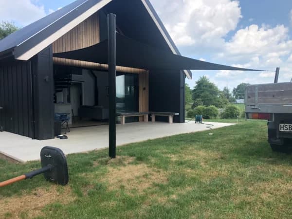 Angled shade sail installation over a backyard patio