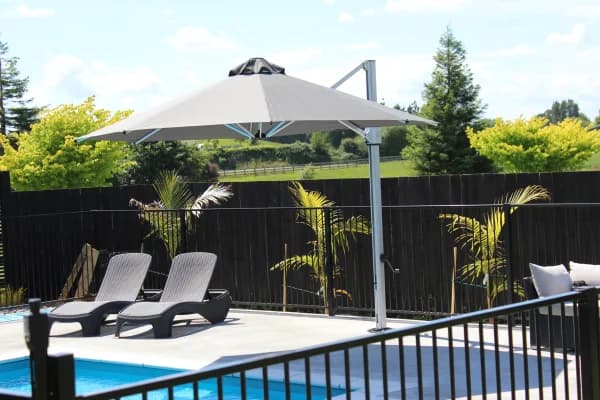 Shade7 Riviera cantilever umbrella shading loungers by a pool