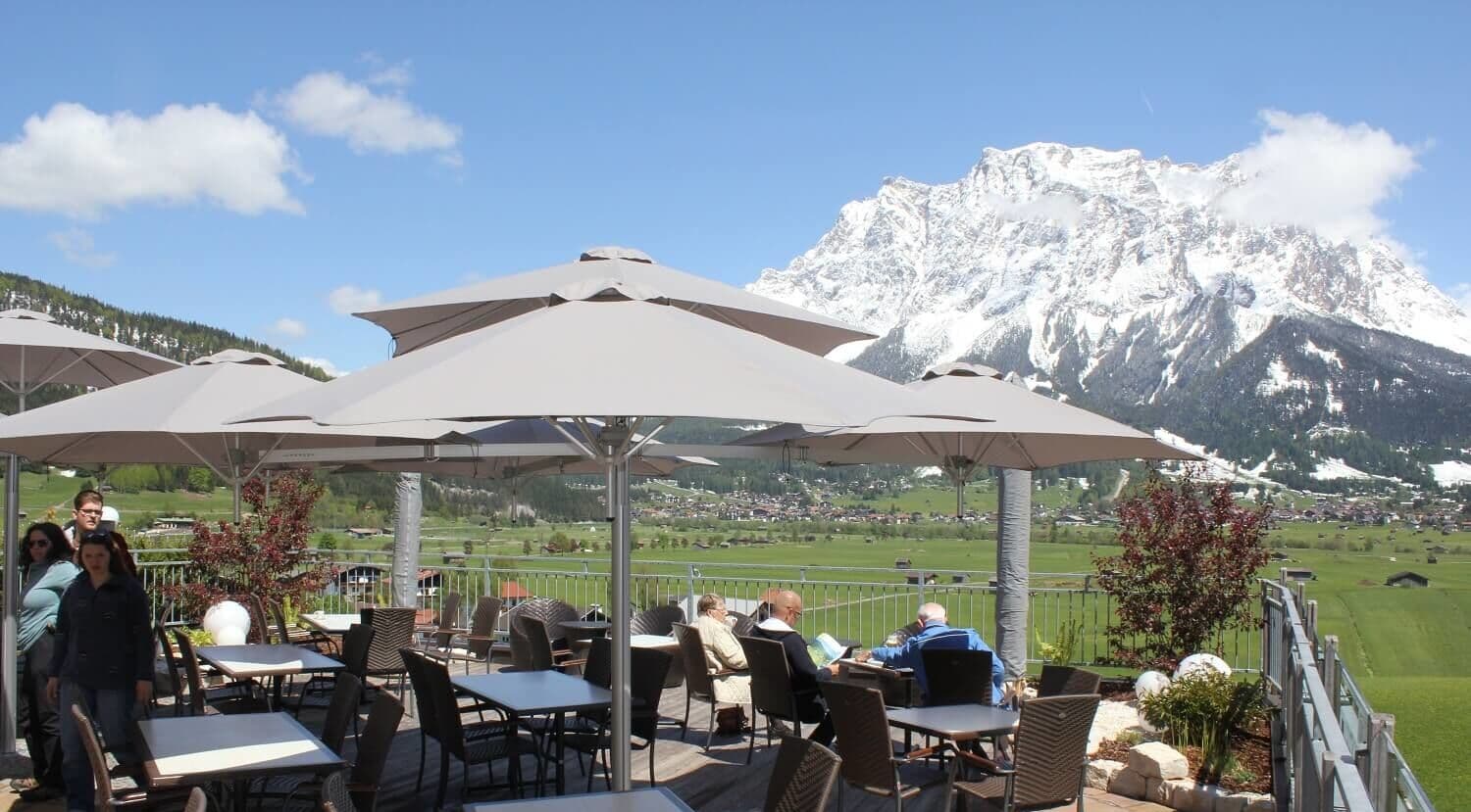 Grey Shade7 Paraflex wall-mounted umbrellas shading a mountain-view terrace