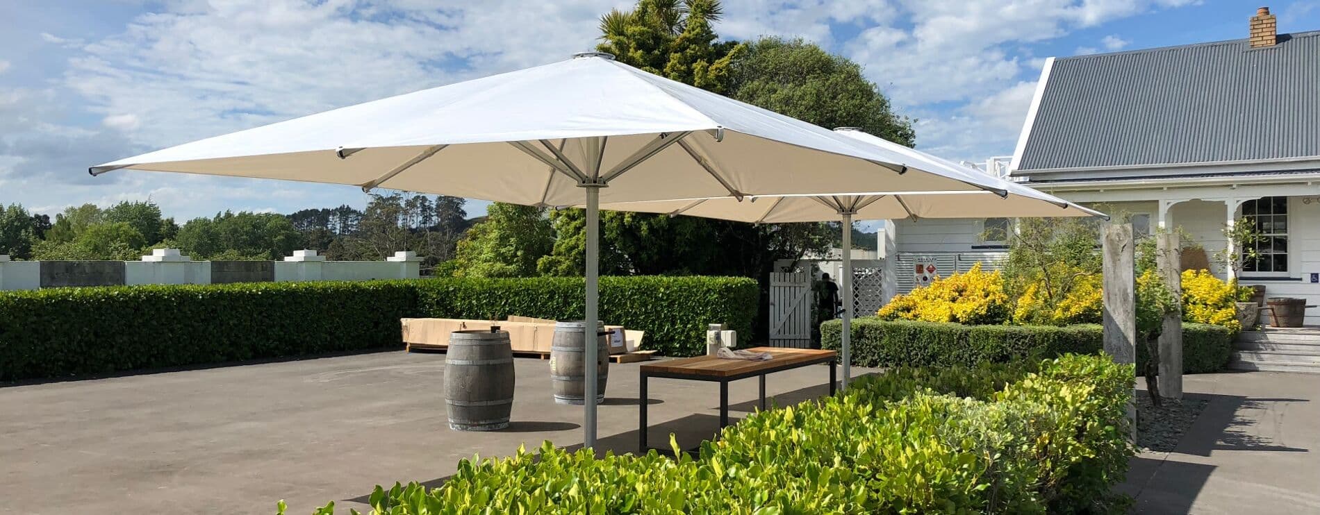 White 5m square Shade7 Tempest umbrella over an outdoor table at a lodge
