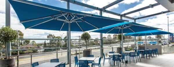 Giant Shade7 Tempest commercial outdoor umbrellas over hospitality seating