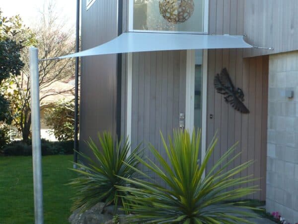 Waterproof shade sail installed above a home barbecue area