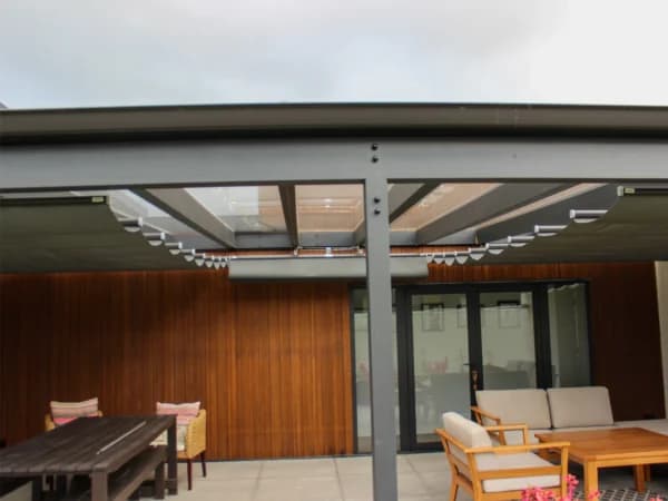 Retractable wave shade extended above an alfresco dining space