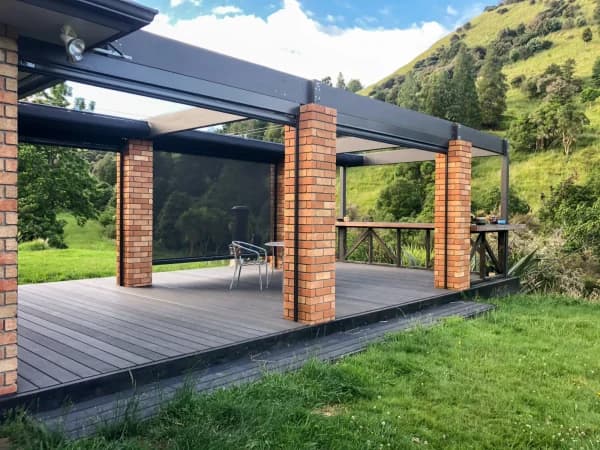 Retractable wave shade sheltering a backyard seating area