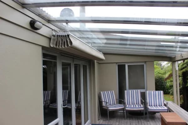 Retractable wave shade canopy above an outdoor lounge area
